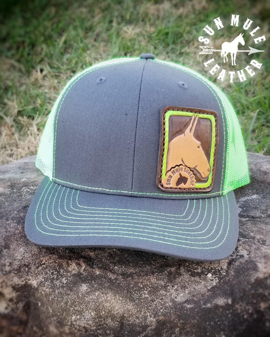 Hand tooled small leather patch  sewn onto a Richardson 112 hat depicting a mule with a neon green border. Hand tooled in the USA, one of a kind. 