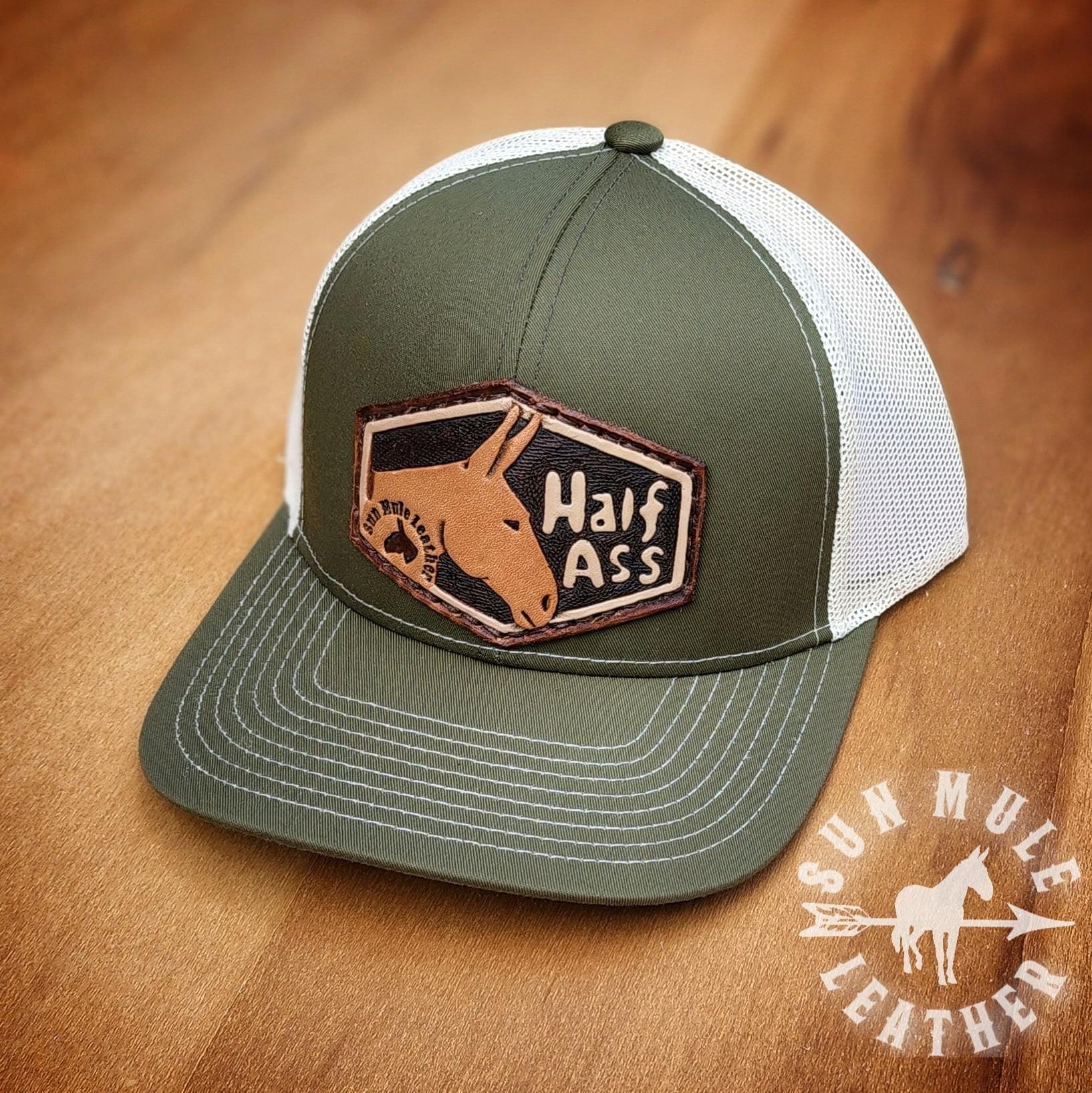 Half ass mule hat in moss green with hand tooled letters and a mule. 