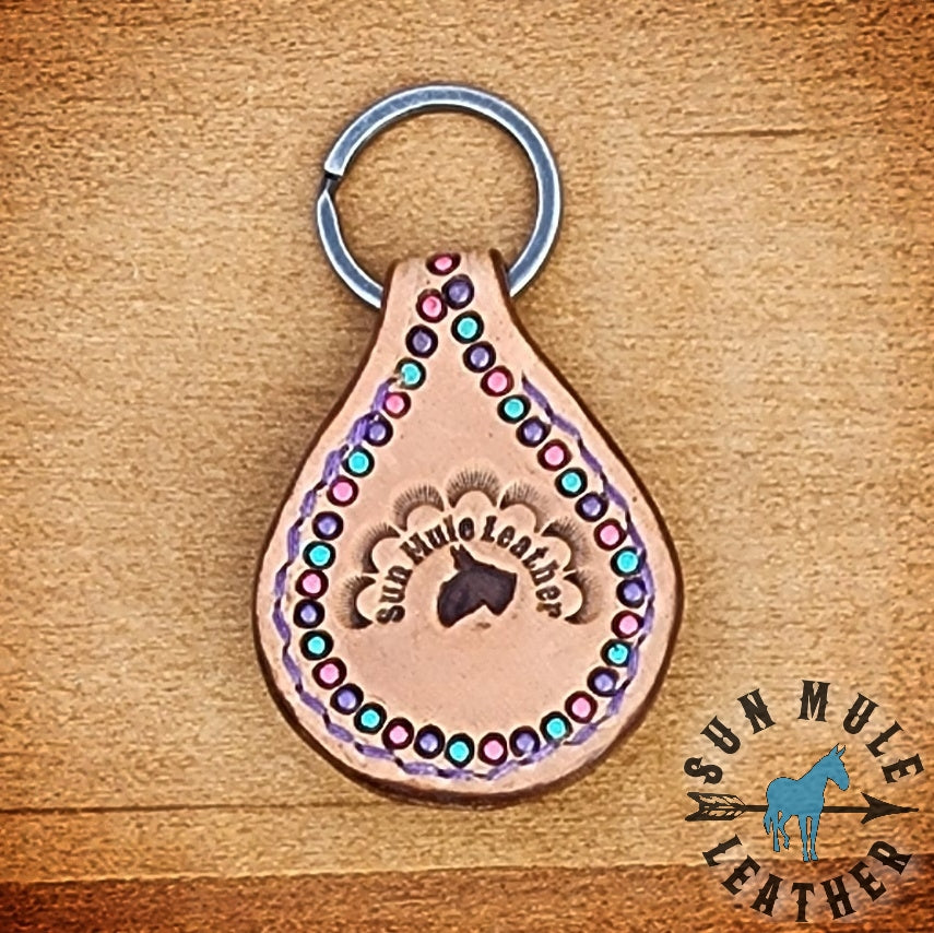 Backside of natural colored handmade leather keychain with a mule concho, on an antiqued flat split key ring. 